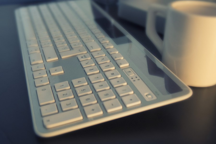 Klawiatura bezprzewodowa na blacie biurka.